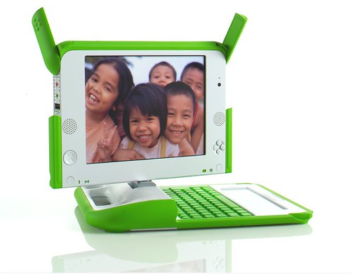 One Laptop Per Child-dator, bärbar, vit med gröna kanter och tangentbord. På skärmen skrattande barn.