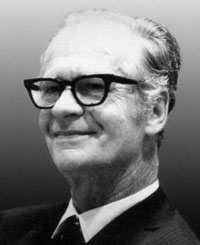 B.F. Skinner - äldre man med mörka glasögon och stort leende.