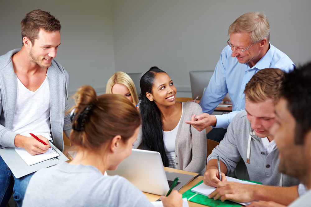 En grupp studenter sitter och arbetar tillsammans kring ett bord.