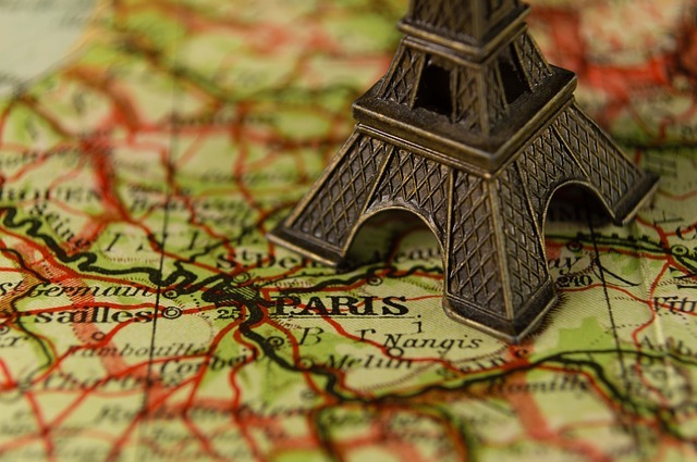 En karta som visar Paris med omgivningar. På kartan står en liten modell av Eiffeltornet.