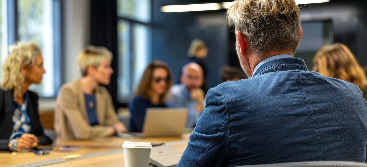 En grupp vuxna som sitter i ett möte.